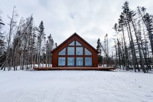 Chalet with large windows and deck in winter